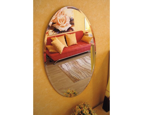 Ovaler Spiegel an einer Wand, der ein Zimmer mit Sofa und Teppich reflektiert