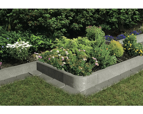 Beetbegrenzung aus Beton mit Bepflanzung im Garten.