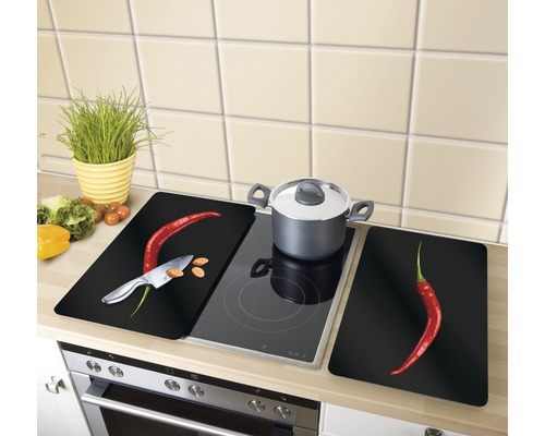 Herdabdeckplatten mit Chili-Motiv auf einem Herd
