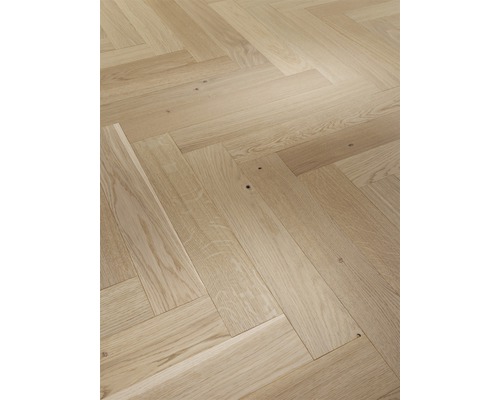 Verlegung von hellem Parkett im Fischgrätmuster.