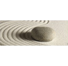 Dekorativer Stein auf Sand mit Wellenmuster