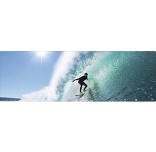 Surfer reitet auf einer Welle auf einem Surfbrett