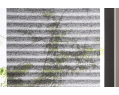 Nahaufnahme einer grauen, horizontalen Plisseejalousie am Fenster