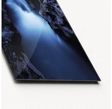Nahaufnahme einer Glasplatte mit einem Wasserfall zwischen Felsen