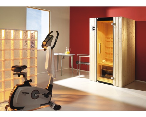 Innenraum mit Sauna, Heimtrainer der Marke Kettler, Tisch, Stuhl und Glasbausteinen