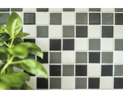 Quadratische Mosaikfliesen an einer Wand.