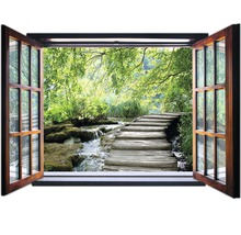 Fenster mit Blick auf einen Waldweg und einen Bach