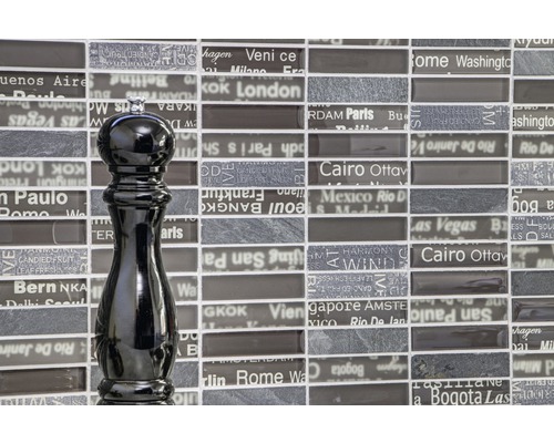 Schwarze Pfeffermühle vor Fliesenwand mit Städtenamen