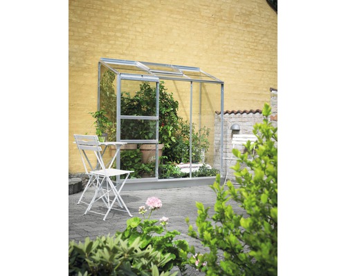 Anlehngewächshaus Halls Altan 3 Blankglas 3 mm 194 x 69 cm Aluminium Wandgewächshaus mit Pflanzen und Gartenmöbeln im Außenbereich