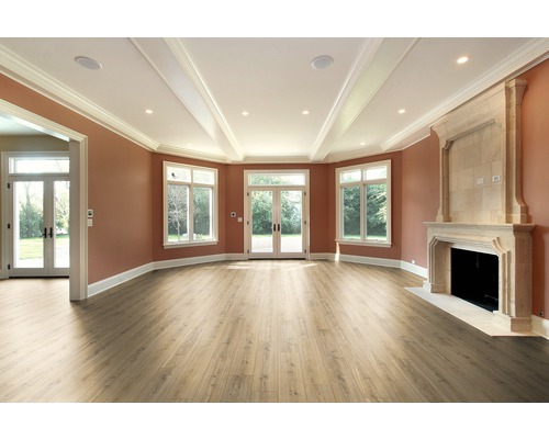 Heller Raum mit Laminatboden, Fenstern, Terrassentür und Kamin