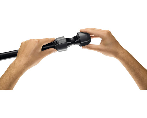 Zwei Hände montieren ein schwarzes Verbindungsstück an einem schwarzen Rohr.