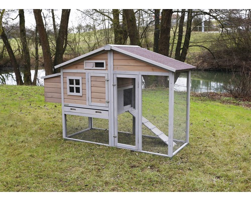 Freistehender Hühnerstall mit überdachtem Auslauf im Garten.