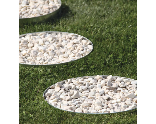 Trittplatten mit weißen Zierkieseln im Garten