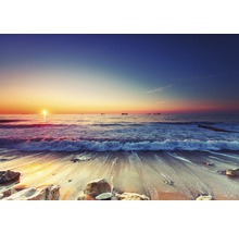 Sonnenaufgang am Strand mit Wellen und Schiffen am Horizont