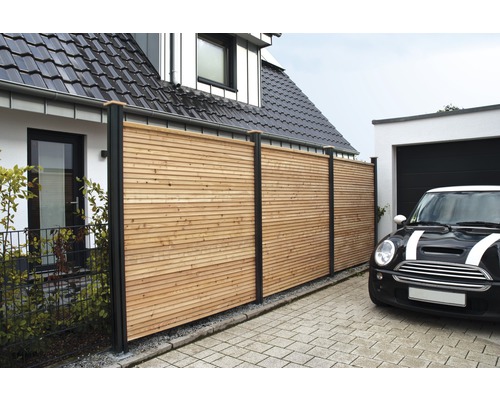 Sichtschutzzaun aus Holz mit schwarzen Pfosten vor einem Haus und einer Garage