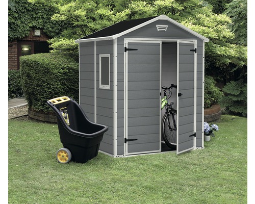 Gartenszene mit grauem Gerätehaus, Schubkarre und Fahrrad zur Gartenaufbewahrung