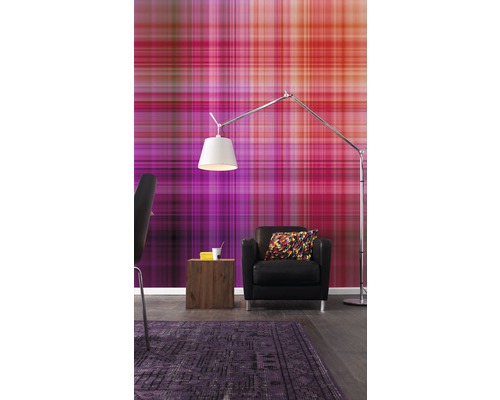 Ein Wohnzimmer mit einer gemusterten Tapete, einem Sessel, einer Stehlampe und einem Teppich.