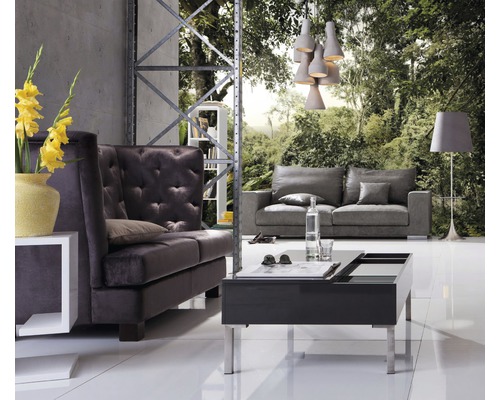 Wohnzimmer mit Sofa, Sessel, Couchtisch und Stehlampe vor einer Waldtapete