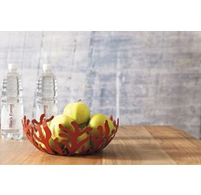 Dekorative Schale mit Äpfeln und Wasserflaschen auf einem Holztisch