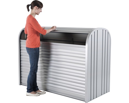 Frau öffnet eine Mülltonnenbox aus Metall mit Rolladen