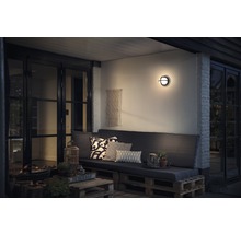 Terrasse mit Sitzbereich, Wandleuchte und dekorativen Elementen für den Außenbereich
