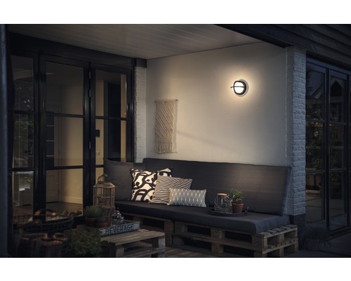 Terrasse mit Sitzbereich, Wandleuchte und dekorativen Elementen für den Außenbereich