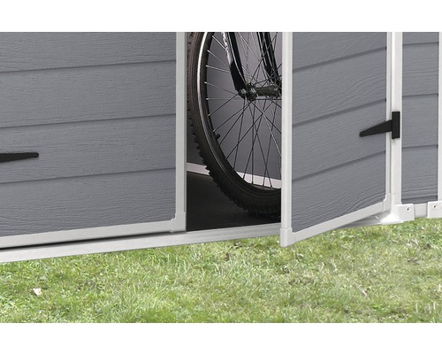 Detailansicht eines geöffneten Gerätehauses mit Fahrrad darin.