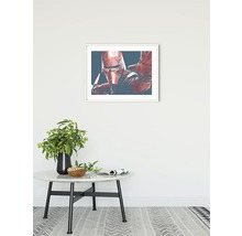 Gerahmtes Bild von einer Figur an einer Wand über einem Tisch.