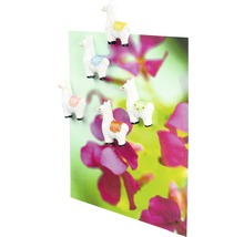 Dekorative Magnete in Lamaform auf einer Karte mit Blumenmotiv