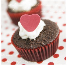 Schokoladenmuffin mit Herzdekoration in roter Papierform