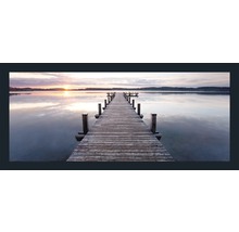 Holzsteg führt auf einen See bei Sonnenuntergang