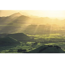 Landschaft mit Hügeln und Feldern im goldenen Licht