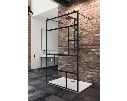 Walk In Duschwand Schulte Alexa Style 2.0 Black Style 118,7 cm Dekor Atelier Begehbare Dusche mit schwarzem Rahmen und Duschkopf in einem Badezimmer mit Waschbecken und Ziegelwand.