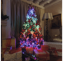 Geschmückter Weihnachtsbaum mit Geschenken in einem Wohnzimmer.