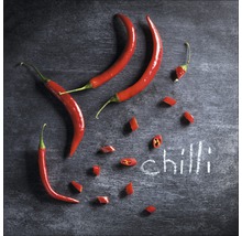 Rote Chilischoten und geschnittene Chilistücke auf dunklem Untergrund