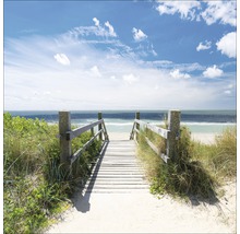 Holzsteg zum Strand mit Meerblick unter blauem Himmel