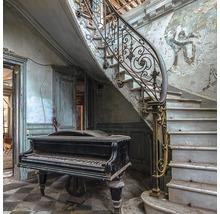 Ein Klavier unter einer Treppe in einem verlassenen Raum.