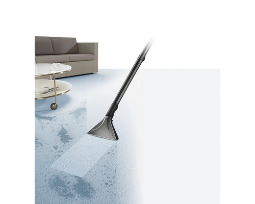 Teppichreiniger im Einsatz zur Fleckenentfernung auf einem Teppichboden