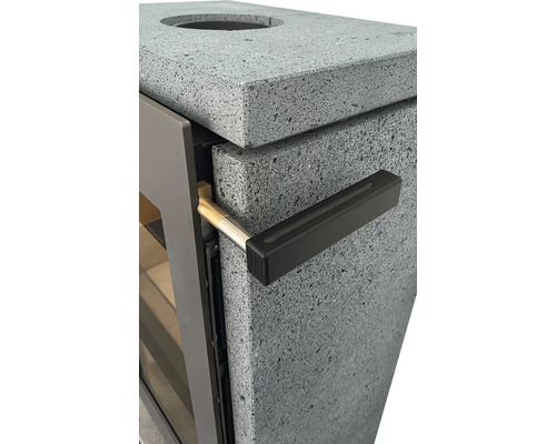 Detailansicht eines Kaminofens mit Natursteinverkleidung und Türgriff