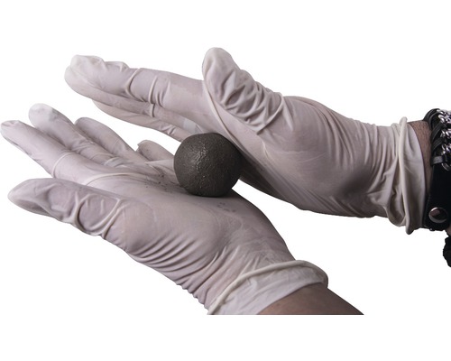 Zwei Hände in Handschuhen halten eine Kugel aus Spachtelmasse