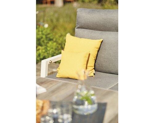Gartensessel mit gelben Zierkissen auf der Sitzfläche