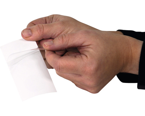 Hände ziehen Schutzfolie von selbstklebender Folie ab