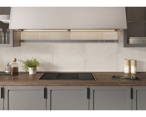 Küchenszene mit Induktionskochfeld, Dunstabzugshaube und Küchenutensilien auf der Arbeitsfläche