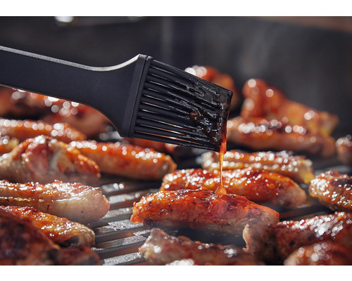 Grillpinsel bestreicht Grillgut auf einem Grill