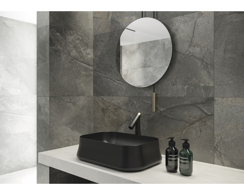 Badezimmergestaltung mit schwarzem Aufsatzwaschbecken, Spiegel und grauen Wandfliesen in Marmoroptik.