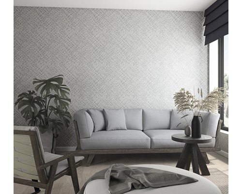 Heller Wohnraum mit gemusterter Tapete, Sofa, Sessel und dekorativen Elementen