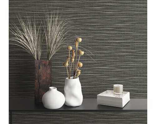 Dekorative Szene mit Vasen und Zierpflanzen vor einer gemusterten Wand.