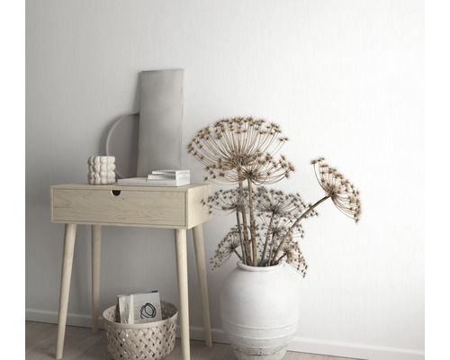 Dekorative Szene mit einem Holztisch, einer Vase mit Trockenblumen und dekorativen Elementen.