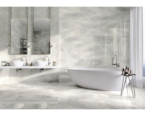 Helles Badezimmer mit Badewanne, Doppelwaschbecken und Wand- und Bodenfliesen in Marmoroptik.