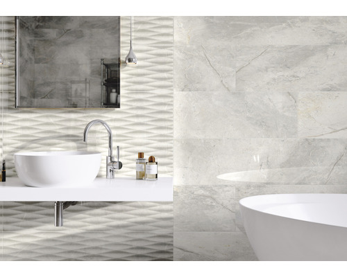 Badezimmer mit Waschbecken, Badewanne und Wandfliesen in Marmoroptik